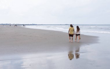 Wijk aan zee, Hollanda, 7 Eylül 2024: Hollanda 'da Kuzey Denizi sahillerinde el ele yürüyen çift
