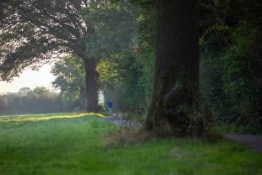 Mavili çocuk, Hollanda 'da Maashees yakınlarında kır yolunda yürüyor.