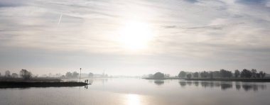 silhouettes of men fishing in river lek at sunrise on early morning in the fall clipart