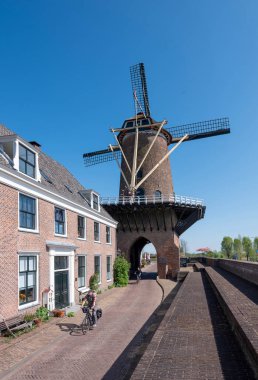 wijk bij duurstede, Hollanda, 20 Nisan 2025: Hollanda yakınlarındaki Wijk bij Duurstede 'de insanlar güneşli bir bahar gününde yel değirmeninden geçiyorlar