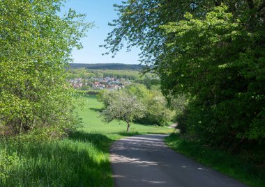Doğa parkının güzel kırsal kesiminde baharda çiçeklenen meyve ağaçları ve mavi gökyüzünün altında taze renkler görülür.