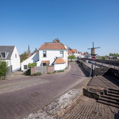 Hollanda 'nın mavi gökyüzünün altında, güneşli bir baharda, Uttrecht yakınlarında, Hollanda' nın wijk bij Duurstede kasabasındaki eski evler ve yel değirmenleri