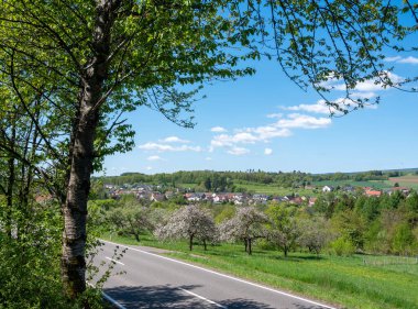 Doğa parkının güzel kırsal kesiminde baharda çiçeklenen meyve ağaçları ve mavi gökyüzünün altında taze renkler görülür.