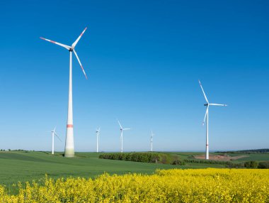 Baharda saarland 'da mavi gökyüzünün altında rüzgar türbinleri olan Alman kırsalları