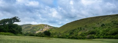 Corfe Kalesi yakınlarındaki tarlalar ve tepeler bulutlu gökyüzünün altında güney dorset kırsalında