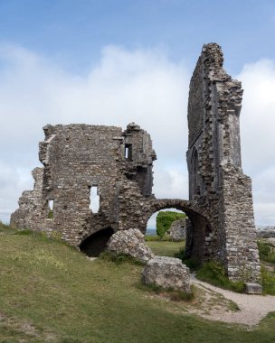 Corfe Kalesi 'nin kalıntıları mavi gökyüzünün altındaki güney dorset kırsalında.