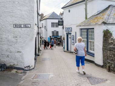 Port Isaac, İngiltere, 22 Haziran 2025: Güneşli bahar gününde Cornish kasabasında eski beyaz evler ve turistler