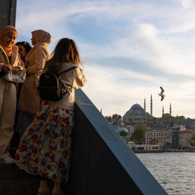 Galata Köprüsü 'ndeki Süleyman Camii' nin fotoğraflarını çeken kadınlar. İstanbul 'da turizm dikey arkaplan fotoğrafı. İstanbul Türkiye - 5.7.2022