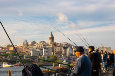 İstanbul 'un vatandaşları. Yerel halk Galata Köprüsü 'nde oltayla balık tutuyor. İstanbul manzarası gün batımında. İstanbul Türkiye - 5.7.2022