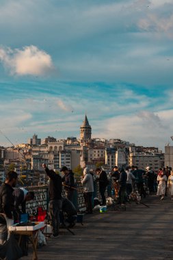 Balıkçılar ve insanlar arka planda Galata Köprüsü ve Galata Kulesi 'nde. İstanbul 'daki dikey arka plan fotoğrafına git. İstanbul Türkiye - 5.7.2022