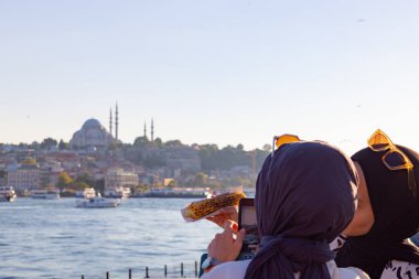 İstanbul 'un fotoğrafını çeken iki Türk başörtüsü kızı. Modern türbanlı Türk kadınları. İstanbul Türkiye - 8.20.2022
