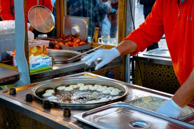 Sokaktaki yemek arabasının yağında lokma kızartan bir adam. Geleneksel Türk tatlıları ya da Lokma pastası ya da Yunanca 'da loukoumades. İstanbul Türkiye - 11.10.2021