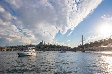 İstanbul gün batımında ufuk çizgisi. Süleyman Camii ve Halic Metro Köprüsü 'nde Altın Boynuz' da tekneleri var. İstanbul Türkiye - 10.4.2022