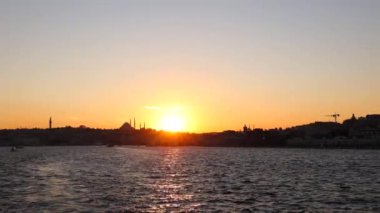 İstanbul manzarası gün batımında. İstanbul 'un silueti bir feribottan. Boğaziçi tur 4K konsept video.