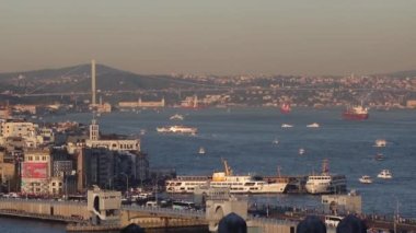 Gün batımında feribotlu Galata Köprüsü ve Karaköy bölgesi. İstanbul 'a tam donanımlı video ile git. İstanbul Türkiye - 9.30.2022