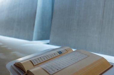 İslami arkaplan. Modern camide beyaz kürsüde Kuran-ı Kerim. Kopya alanı olan Ramazan veya Kandil konsepti fotoğrafı. İstanbul Türkiye - 11.12.2022