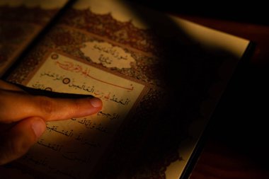 İslami konsept. Müslüman adam Kuran 'ı işaret ediyor. Metinler için fotokopi alanı olan İslami veya ramazan arkaplan fotoğrafı. İstanbul Türkiye - 9.30.2022