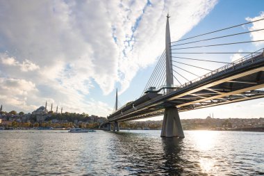 Halic Metro Bridge and cityscape of Istanbul with cloudy sky at sunset. Istanbul Turkiye - 10.4.2022