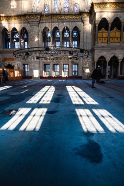 Shadows of the windows on the carpet in Nuruosmaniye Mosque. Islamic background vertical photo. Istanbul Turkiye - 12.23.2022
