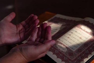 Muslim man praying with the Holy Quran in a mosque. Islamic photo. Ramadan background photo. Istanbul Turkiye - 9.30.2022