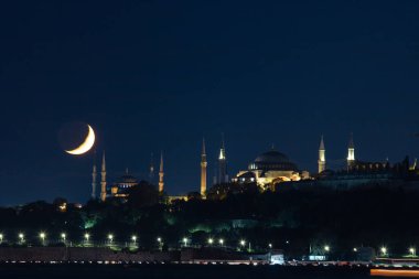 Ramadan concept photo. Crescent moon with Ayasofya or Hagia Sophia and Blue Mosque or Sultanahmet at night. Islamic background photo.
