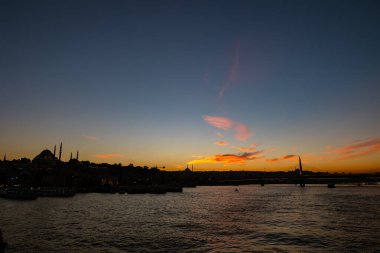 Istanbul skyline. Silhouette of Istanbul at sunset from Galata Bridge. Suleymaniye Mosque and Halic Metro Bridge. Islamic or ramadan concept photo.