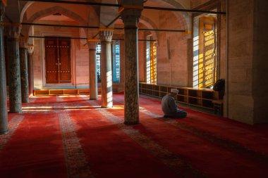 Ramadan or islamic background photo. Muslim man praying in the mosque. Suleymaniye Mosque and muslim man. Kandil or kadir gecesi or laylat al-qadr concept. Istanbul Turkiye - 12.31.2022