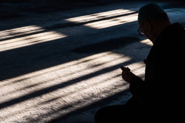 Islamic photo. Silhouette of a muslim man praying in the mosque. Ramadan or kandil or laylat al-qadr or kadir gecesi concept photo with copy space for texts.