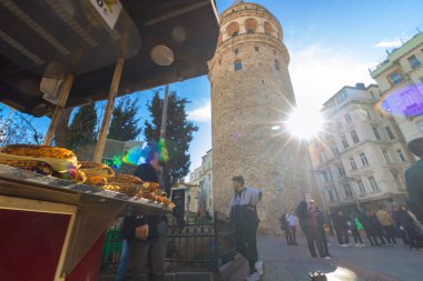 Grilled corn on the food cart and people with Galata Tower on the background. Travel to Istanbul background photo. Istanbul Turkiye - 1.18.2023