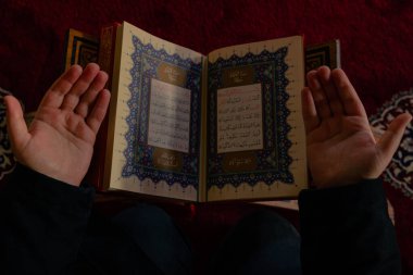 İslami arkaplan. Müslüman adam camide Kuran 'la namaz kılıyor. Ramazan, İslami ya da laylat al-Qadr ya da kadir gecesi arkaplan fotoğrafı. İstanbul Türkiye - 1.18.2023