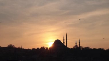 Ramazan ya da İslami konsept 4k video. Günbatımında Süleyman Camii. İstanbul 'un Martılı Silueti.