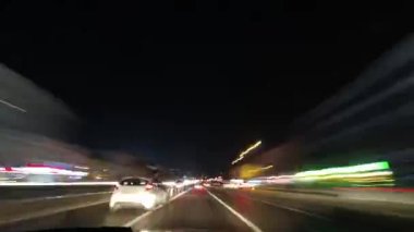 Şehir yollarının hızlandırılmış görüntüleri. Şehir trafiğinin hareket bulanıklığı. Gece 4K videosunda sürüş.