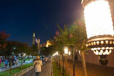 Ayasofya geceleri. Sultanahmet Meydanı 'nda turistler. Ramazan, İslami ya da İstanbul 'daki arka plan fotoğrafına seyahat. Seçici odaklanma. İstanbul Türkiye - 8.12.2022
