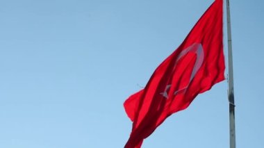 Mavi gökyüzü arka planında Türk Bayrağı sallıyor. 4k video. Türkiye 'de resmi tatil.