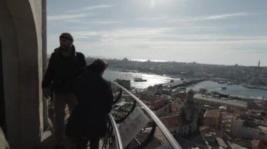 4K POV videosunda Galata Kulesi 'nin balkonunda ve İstanbul şehir manzarasında turistler görülüyor. İstanbul Türkiye - 1.18.2023