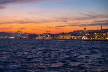 İstanbul manzarası gün batımında. İstanbul 'da bir feribottan şehir manzarası. Galataport manzaralı Süleyman Camii ve Galata Kulesi.