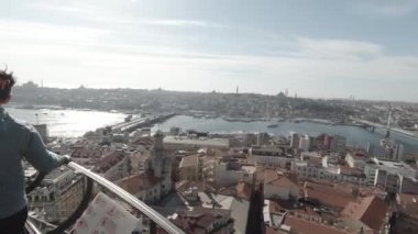 Kışın Galata Kulesi 'nden İstanbul' un fotoğraflarını ya da videolarını çeken turistler. İstanbul 'u ziyaret edin. 4K video kaydı. İstanbul Türkiye - 18.1.2023