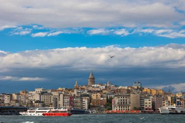 İstanbul manzaralı. Galata Kulesi ve parçalı bulutlu gökyüzü feribotları. İstanbul Türkiye - 9.21.2022