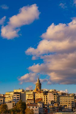 Galata Kulesi ve parçalı bulutlu gökyüzü gün batımında dikey görüntüde. İstanbul 'daki arka plan fotoğrafına git. İstanbul Türkiye - 10.4.2022