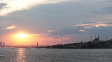 İstanbul gün batımını İstanbul Boğazı 'nda bir feribottan seyrediyor. İstanbul konsept videosunu ziyaret edin. Arka planda Sultanahmet veya Mavi Cami.