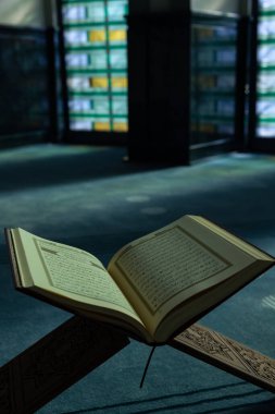 İslami ya da ramazan arka planı dikey fotoğraf. Kutsal Kur 'an' ı kitap standına ya da bir camide Rahle 'a. İstanbul Türkiye - 10.28.2023