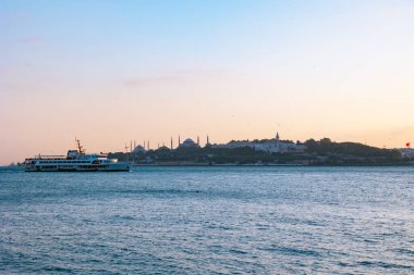 İstanbul arka plan fotoğrafı. İstanbul 'un tarihi yarımadası ve gün batımında bir feribot.
