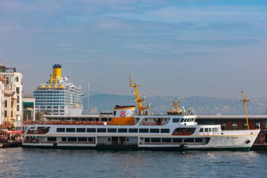 İstanbul konsept fotoğrafını ziyaret edin. Karaköy İskelesi 'ne bir feribot yanaştı ve arka planda bir yolcu gemisi. İstanbul Türkiye - 12.30.2023