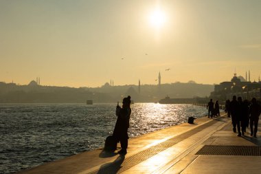 İstanbul manzaralı ve Galataport 'ta fotoğraf çeken bir kadın. İstanbul Türkiye - 12.24.2022