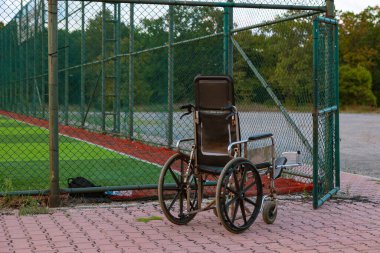 Futbol ya da futbol sahasının açık kapısının yanında boş bir tekerlekli sandalye. Engellilerin yaşam konsepti fotoğrafı.