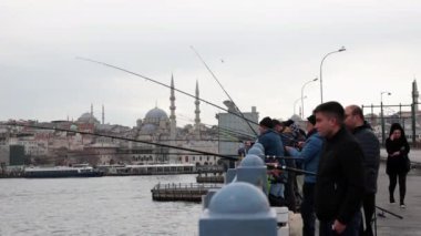 İstanbul 'daki Galata Köprüsü' nden balıkçılar ve Eminonu Yeni Camii. İstanbul Türkiye - 3.31.2023