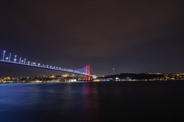 Bosphorus Bridge aka 15 temmuz sehitler koprusu and Anatolian side of Istanbul view at night.