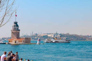 Kiz Kulesi namı diğer Bakire Kulesi İstanbul manzaralı ve feribotlu. İstanbul Türkiye - 4.5.2024