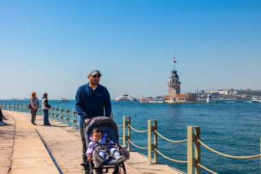 Kiz Kulesi, nam-ı diğer Bakire Kulesi ve insanları. İstanbul konsept fotoğrafını ziyaret edin. İstanbul Türkiye - 4.5.2024