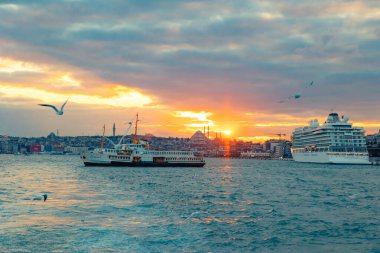 İstanbul manzarası gün batımında. İstanbul 'un deniz ve şehir manzaralı feribot ve martılar. İstanbul Türkiye - 1.22.2024